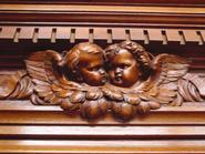 narrow walnut cabinet with cherub faces 19th century