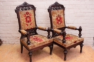 Pair renaissance style arm chairs in walnut.