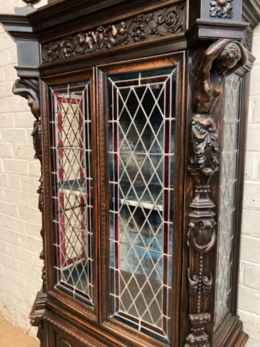 Figural renaissance cabinet in walnut with stain glass
